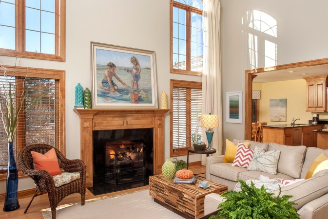 A fresh living room with large windows and a fireplace.
