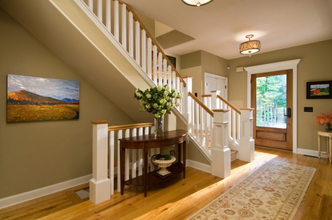 An entryway with hardwood floors and a stylish Demilune Table.