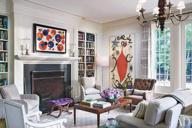 An Alexa Hampton-designed living room with white furniture and a fireplace.