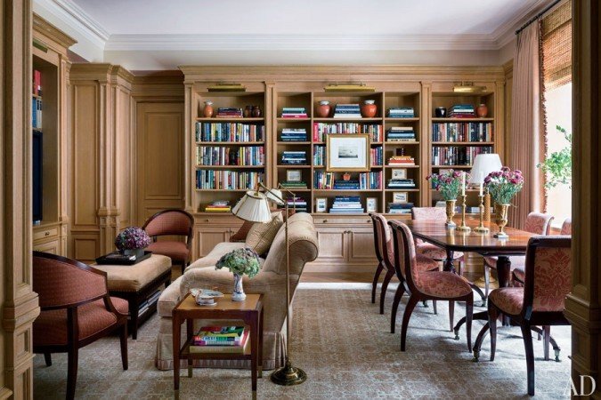A living room designed by Alexa Hampton featuring bookshelves and a dining table.