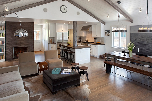 A spacious open kitchen and living room adorned with rustic wooden beams.