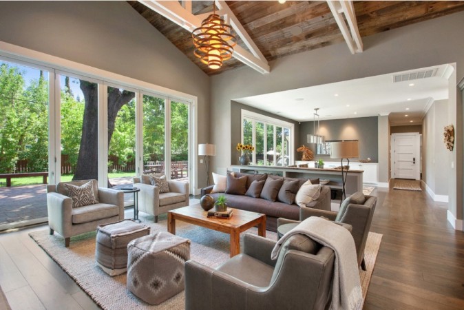 A living room with wood ceilings and gray furniture, perfect for enjoying the open floor plan.