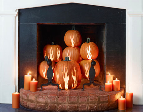 A fireplace with pumpkins and candles, essential for a cozy fall home.