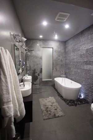 A bathroom with gray walls and a bathtub.
