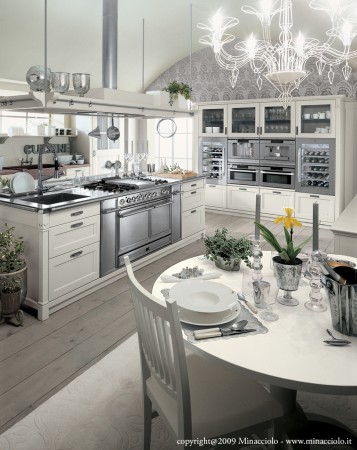 A gray and white kitchen with a table and chairs.