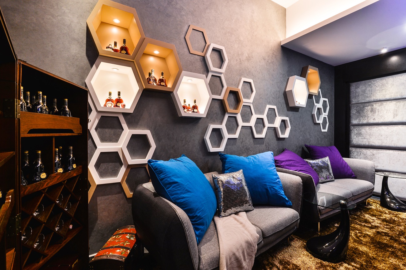 A living room with a wall of hexagonal shelves in a uniquely stylish design.