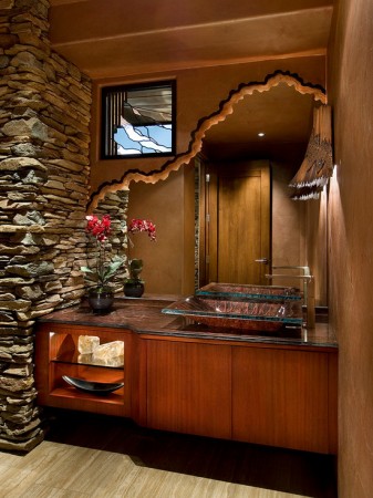 A bathroom with a stone wall featuring panache.