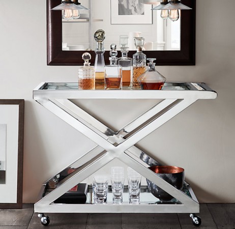 A household champion, the bar cart, features a mirror and glasses.