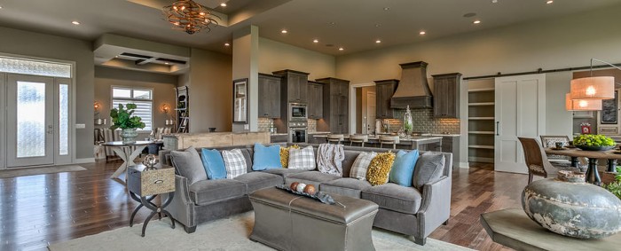 A living room with hardwood floors and a gray couch, perfect for enjoying the open floor plan.