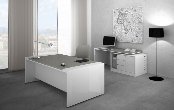 A modern office with a gray desk and a lamp.