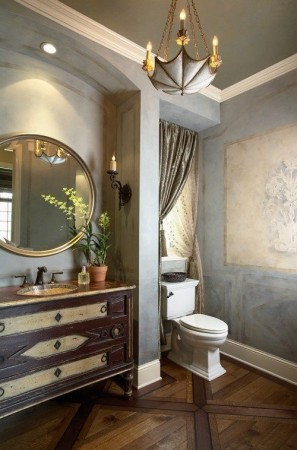 A bathroom with wood floors and a large mirror, exuding panache.