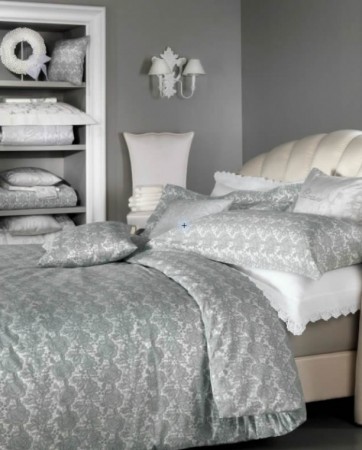 A gray and white bedroom with a bed and dresser.