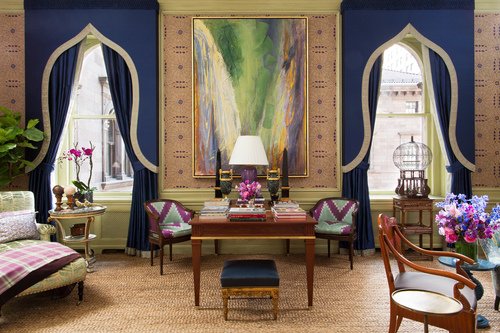 A blue and purple living room with a large painting on the wall, designed by Alexa Hampton.