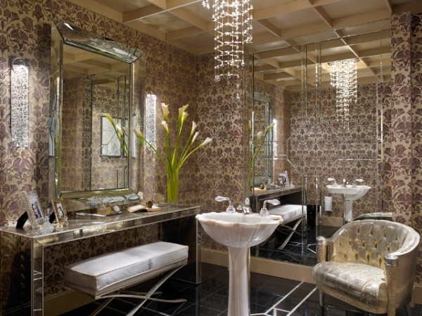 A bathroom with stylish gold wallpaper and a mirror.