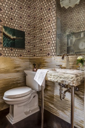 A bathroom with gold wallpaper and a toilet exuding panache.
