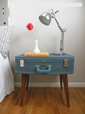 A blue nightstand with a lamp on it.