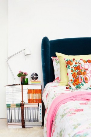A bedroom with a colorful bed and nightstands.
