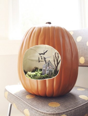Michaels Custom Carved Pumpkin with a miniature house inside.