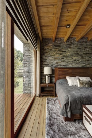 A bedroom with a stone wall, showcasing how to make stone walls work inside your home.