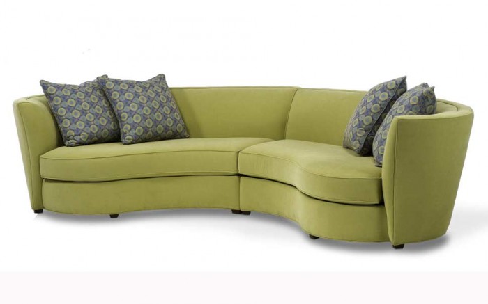 A fun and unique green sectional sofa with blue pillows.