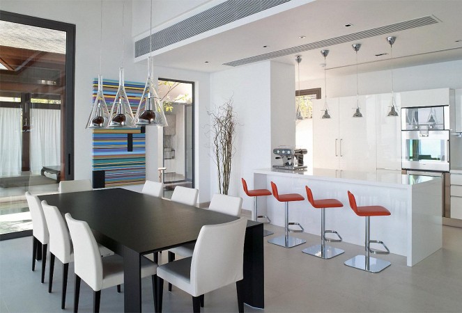 A modern open kitchen with a white table and chairs.