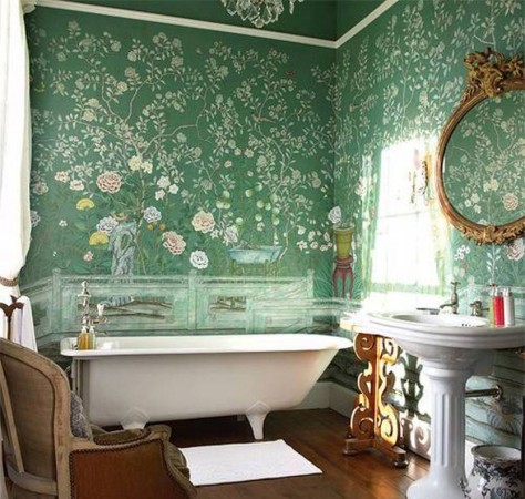 A bathroom with a green floral wallpaper, showcasing the elegance and charm of the clawfoot bathtub.