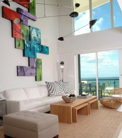A vibrant living room with colorful paintings adorning the walls, featuring vertical interior design elements.