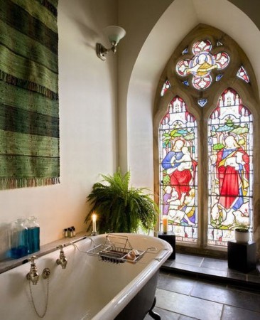 A bathroom with a stained glass window in a restored church turned family home.