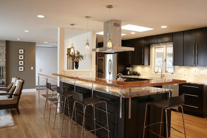An open kitchen featuring a large island and bar stools.