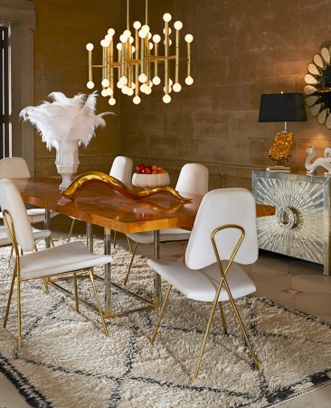 A dining room displaying exquisite interior design with a table, chairs, and a chandelier.