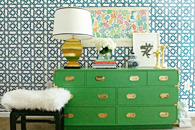A vibrant green dresser in a room with attention-grabbing feature wallpaper.