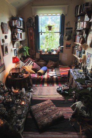 A room with a lot of bookshelves and a bed, styled for the ultimate Bohemian bedroom.