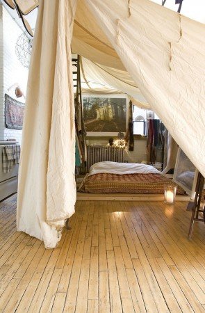 Styling a bohemian bedroom with a tent and wooden floors.