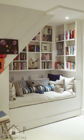A beautiful room with bookshelves under the stairs.