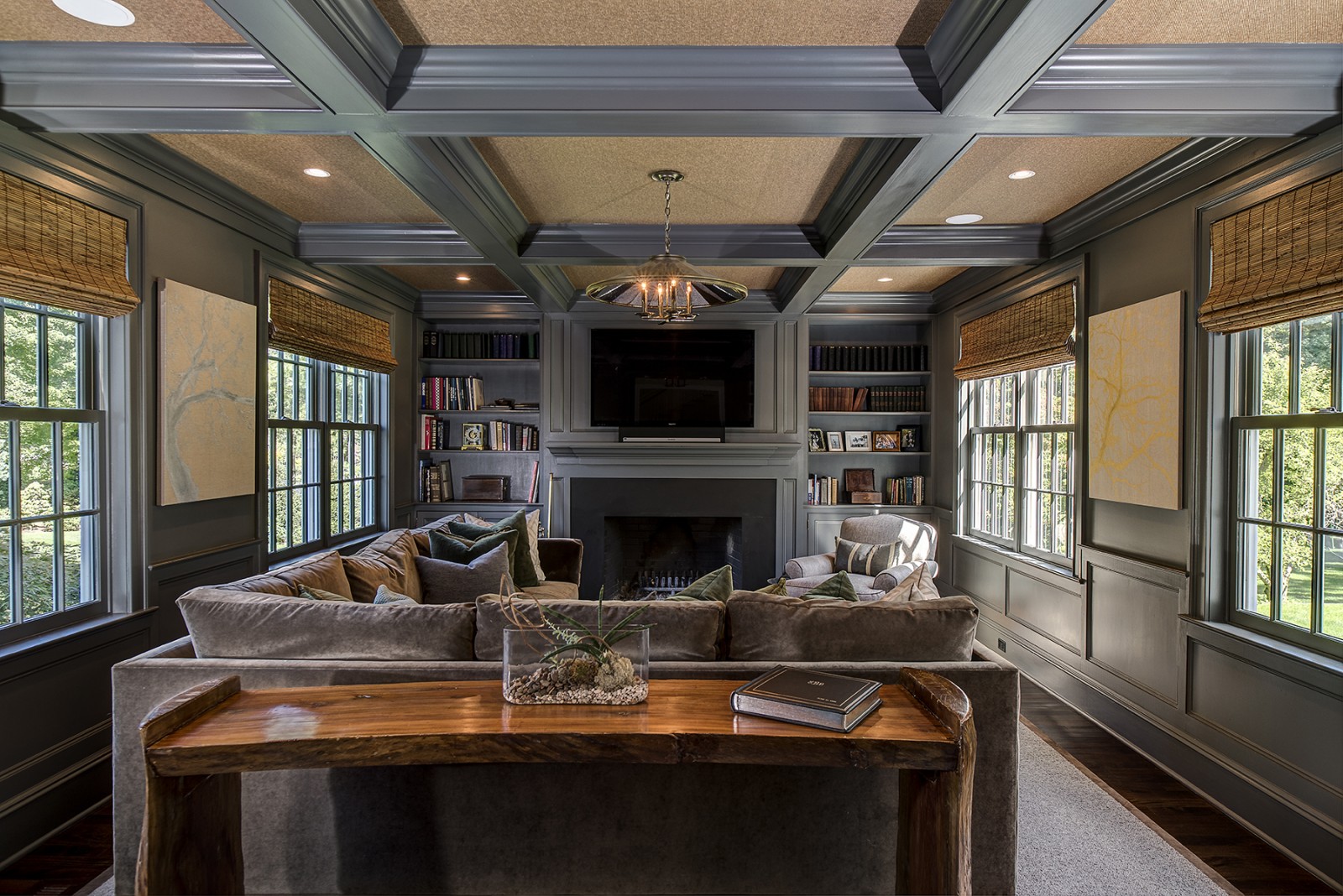 A living room with couches and a fireplace featuring a coffered ceiling.