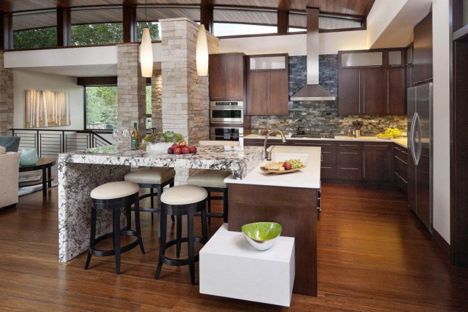 An open kitchen with a center island and bar stools.