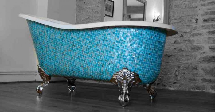 A blue and white tiled clawfoot bathtub adds elegance and charm to any room.
