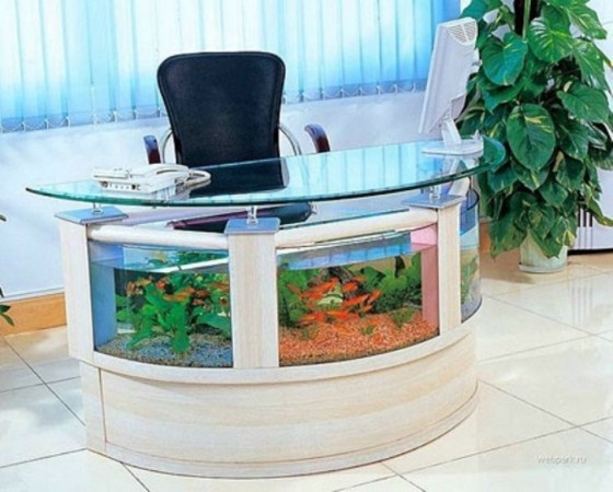 An office desk with an aquarium in it.