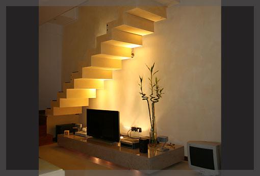 A light-filled living room staircase with a tv on top.