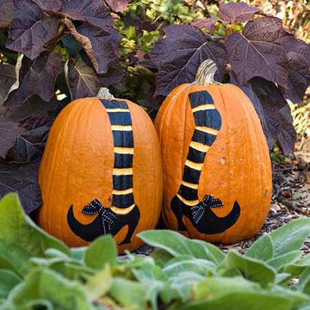 Two Michaels Custom Carved pumpkins painted with black and white stripes.