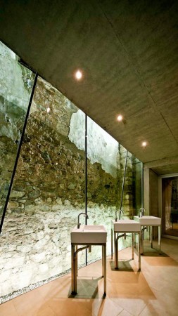 A bathroom with two sinks and a stone wall in a restored church-turned-family home.