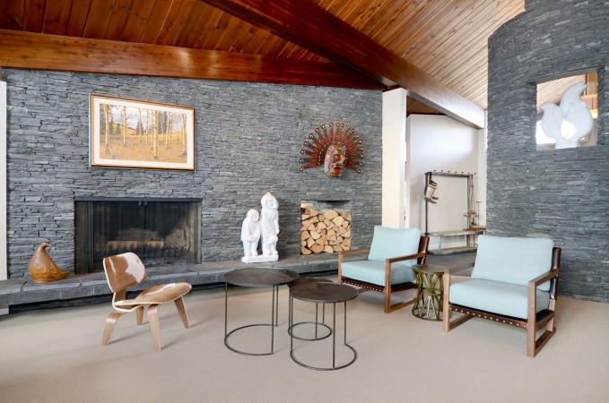 A Mid-Century Modern style living room with a stone fireplace.