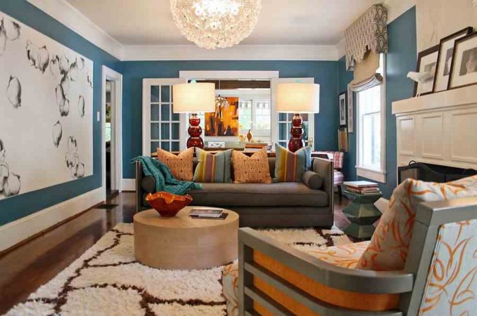 An artistic living room with vibrant orange furniture against blue walls, showcasing interior design as an art form.