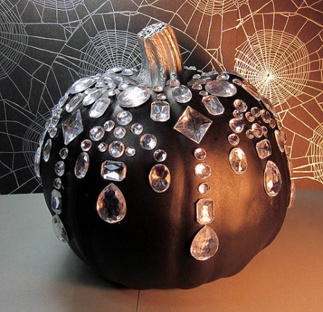 A black pumpkin with crystals and spider webs from Michaels.