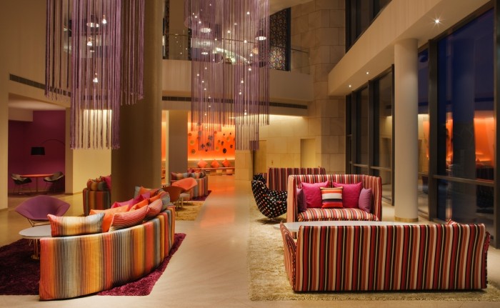 A living room with couches and chairs that highlights the influence of hotel lobbies on interior design.