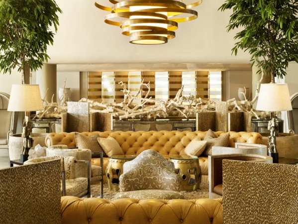 The lobby of a hotel is decorated with lavish gold furniture.