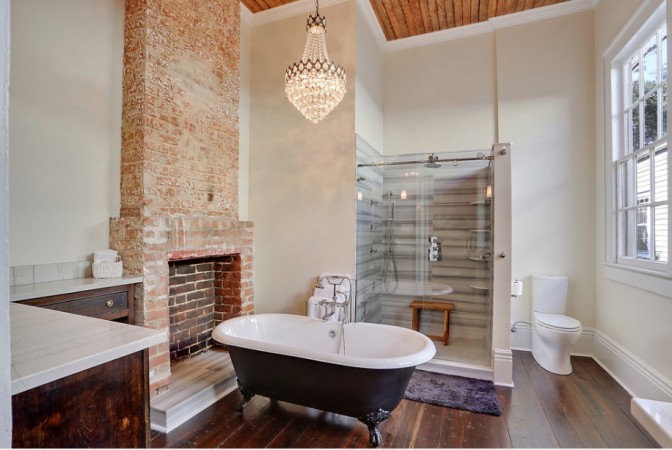 A bathroom with an elegant clawfoot bathtub paired with a charming brick fireplace.