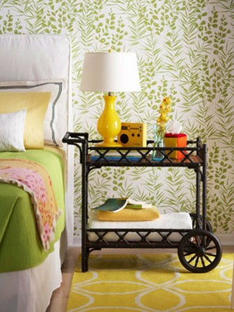 A yellow and green bedroom with floral wallpaper featuring nightstands.