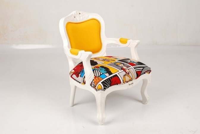 A white and yellow chair with a pop art upholstered seat.