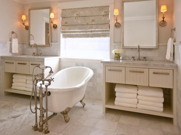 A bathroom with a white clawfoot tub and two mirrors.